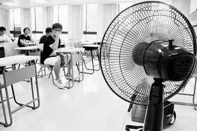 天气炎热,一些考场没冷气就用电扇降温。