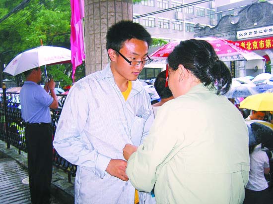北京2中考点外,妈妈为刚出考场的儿子添加衣服。实习生 郭 莉摄 北京2中考点外,妈妈为刚出考场的儿子添加衣服。实习生 郭 莉摄