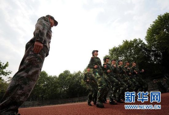 4月27日，一名教官（左）在对国防生进行跑步动作训练。