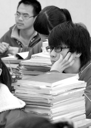 广雅中学一名学生在堆满复习书的案前认真思考。(资料图片)信息时报实习生 陈卓达 记者 巢晓 摄